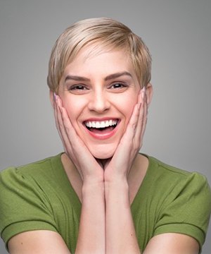Young woman smiling wide and pleased with her dental crowns in Virginia Beach