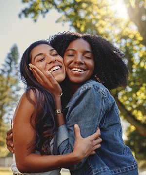 friends smiling and hugging each other