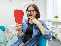  young woman admires her new dental implants in Virginia Beach