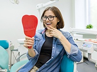 young woman admires her new dental implants in Virginia Beach