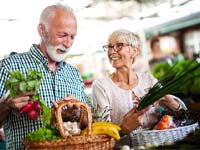 senior man and woman shopping for fruits and vegetables