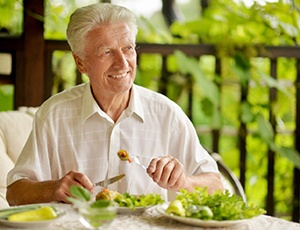 Older man enjoying benefits of implant dentures in Virginia Beach