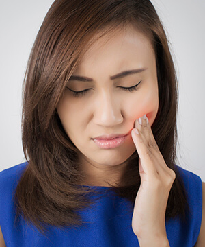 Woman in pain holding her cheek