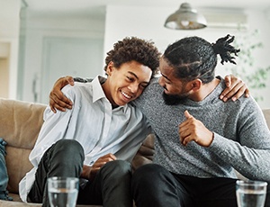 Teen smiling with father after wisdom tooth removal