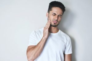 man holding his jaw in pain