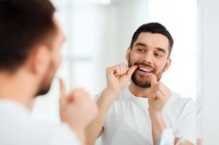 Man flossing in the mirror 