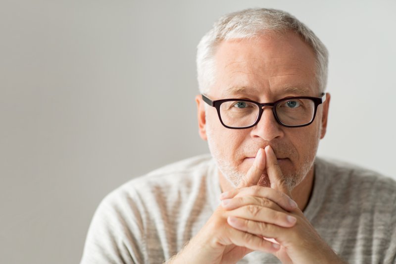 An older man thinking about a dental savings plan.