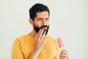 Pained man holding popsicle should see Virginia Beach dentist