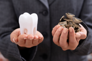 Hands holding tooth and coins