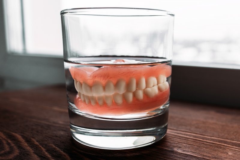 Soaking dentures in a glass of water