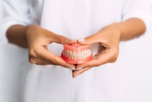 a closeup of dentures in someone’s hands