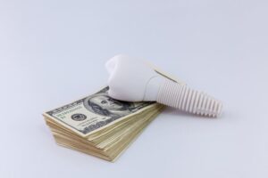 Dental implant next to cash