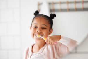 Young girl brushing her teeth with fluoride toothpaste