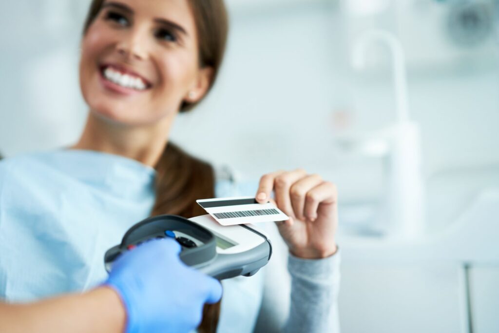 A woman paying for dental treatment with a credit card